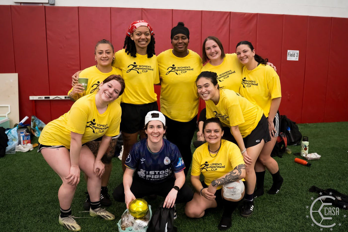 Women's yellow futsal team gathered together on the field