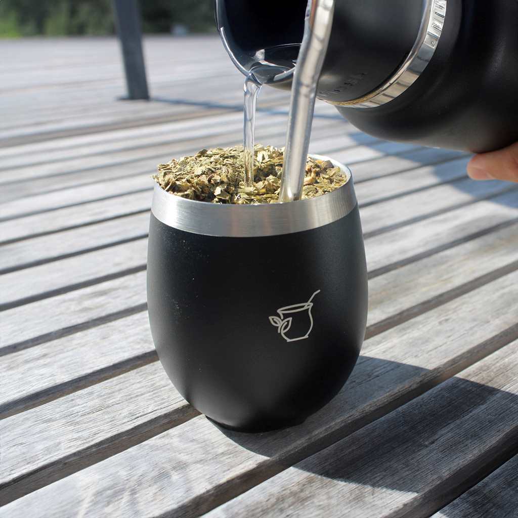 Pouring yerba mate into a stainless steel gourd
