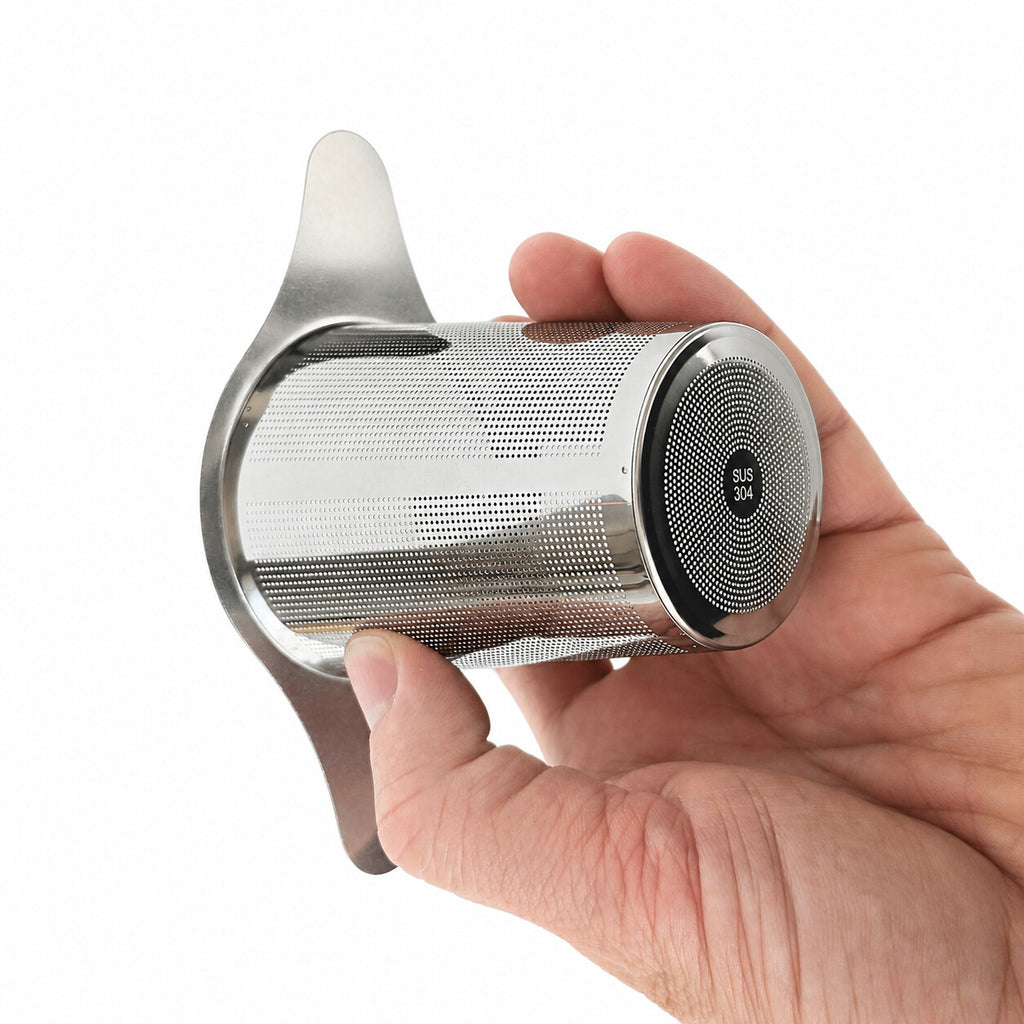 Hand holding the cylindrical stainless steel infuser basket with fine mesh.
