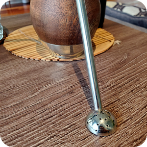 Alpaca silver bombilla straw half sphere filter against wooden mate gourd