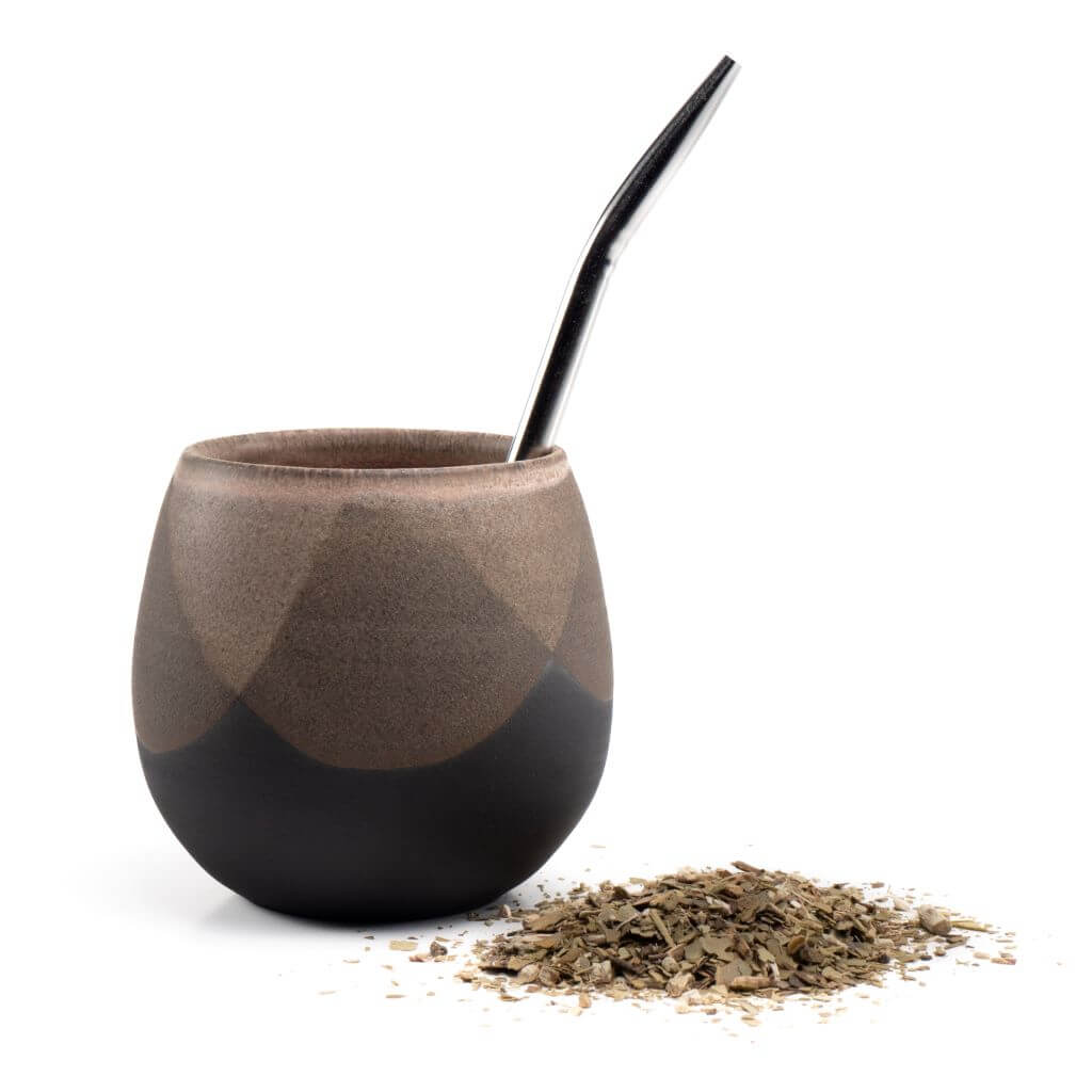 Puma Gold mate cup next to Argentina yerba leaves